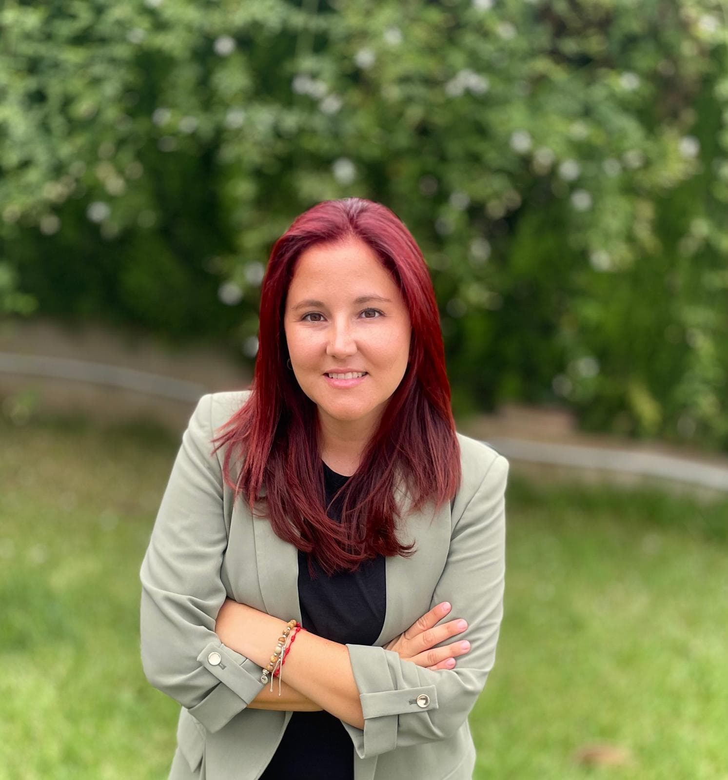 Retrato de Lorena Corell al aire libre, con americana clara y los brazos cruzados